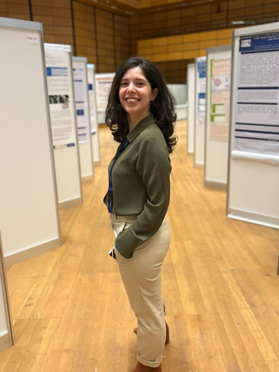 Termeh Shakery standing in a conference poster hall, smiling towards the camera.